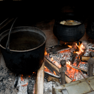 a hearth with two large kettles over the fire