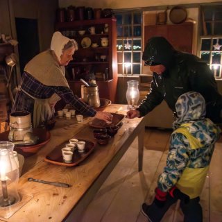 A parent and child grab a sample cup of mulled cider